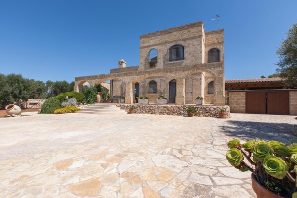 A stone building with arched windows and a courtyard.