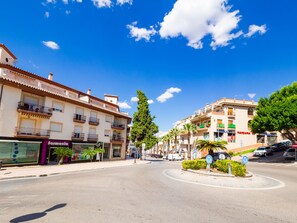 Une vue de rue avec des immeubles, un rond-point et une pharmacie.