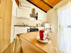 Enjoy meals at the dining table in this modern kitchen with a view of the outdoors.