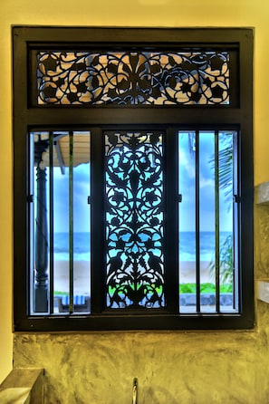 Enjoy the ocean view through this window with a decorative metal grille.