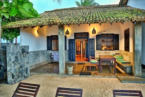 Traditional building with a covered patio area featuring a stone column and wooden bench.