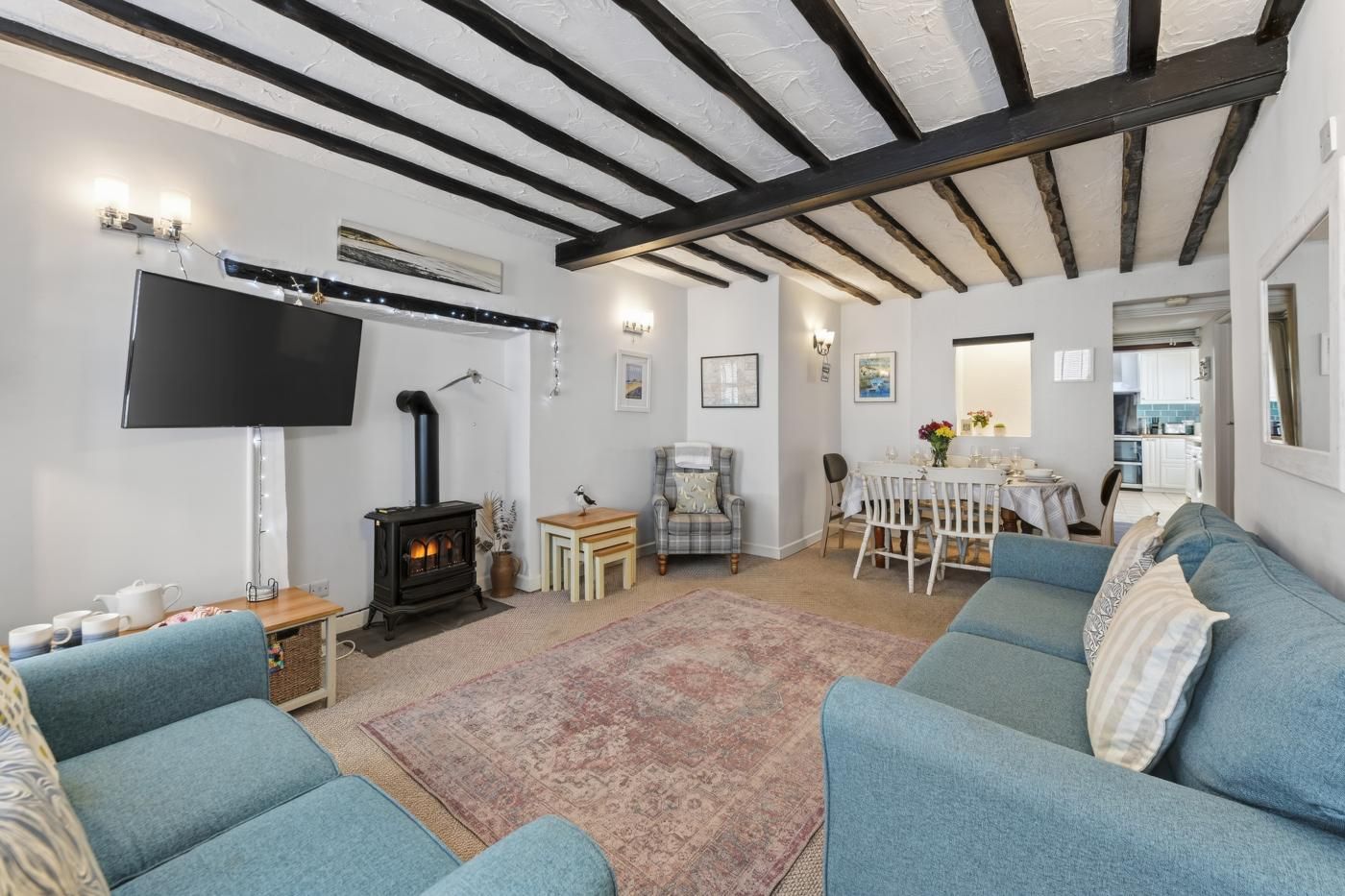A cozy living room with a fireplace, a flat-screen TV, and a dining area with a table and chairs.
