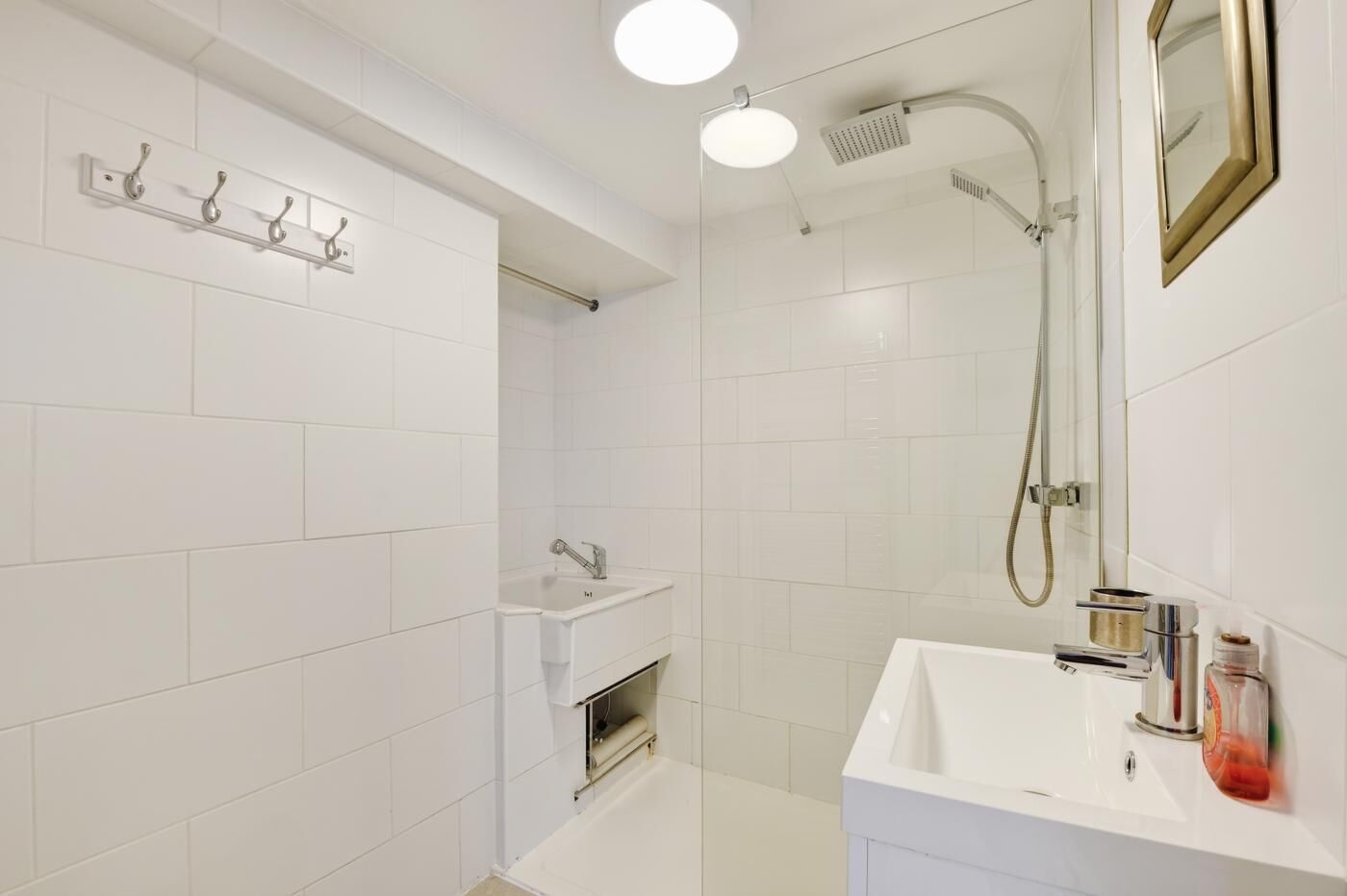 A modern bathroom with a shower, a sink, and a mirror.