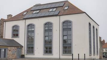 A building with large windows and a sloped roof with solar panels.