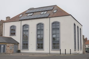 A building with large windows and a sloped roof with solar panels.