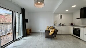 Eine moderne Küche mit Essbereich, einer Couch und einem Fernseher.