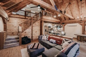 Relax in a spacious living area with a high ceiling and comfortable seating, perfect for unwinding.