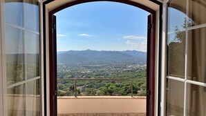 A balcony with a view of a valley and mountains.