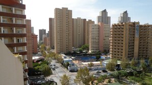 A residential area with high-rise apartment buildings, a swimming pool, and a tennis court. - GIJON (1 BEDROOM) BENIDORM (Benidorm)
