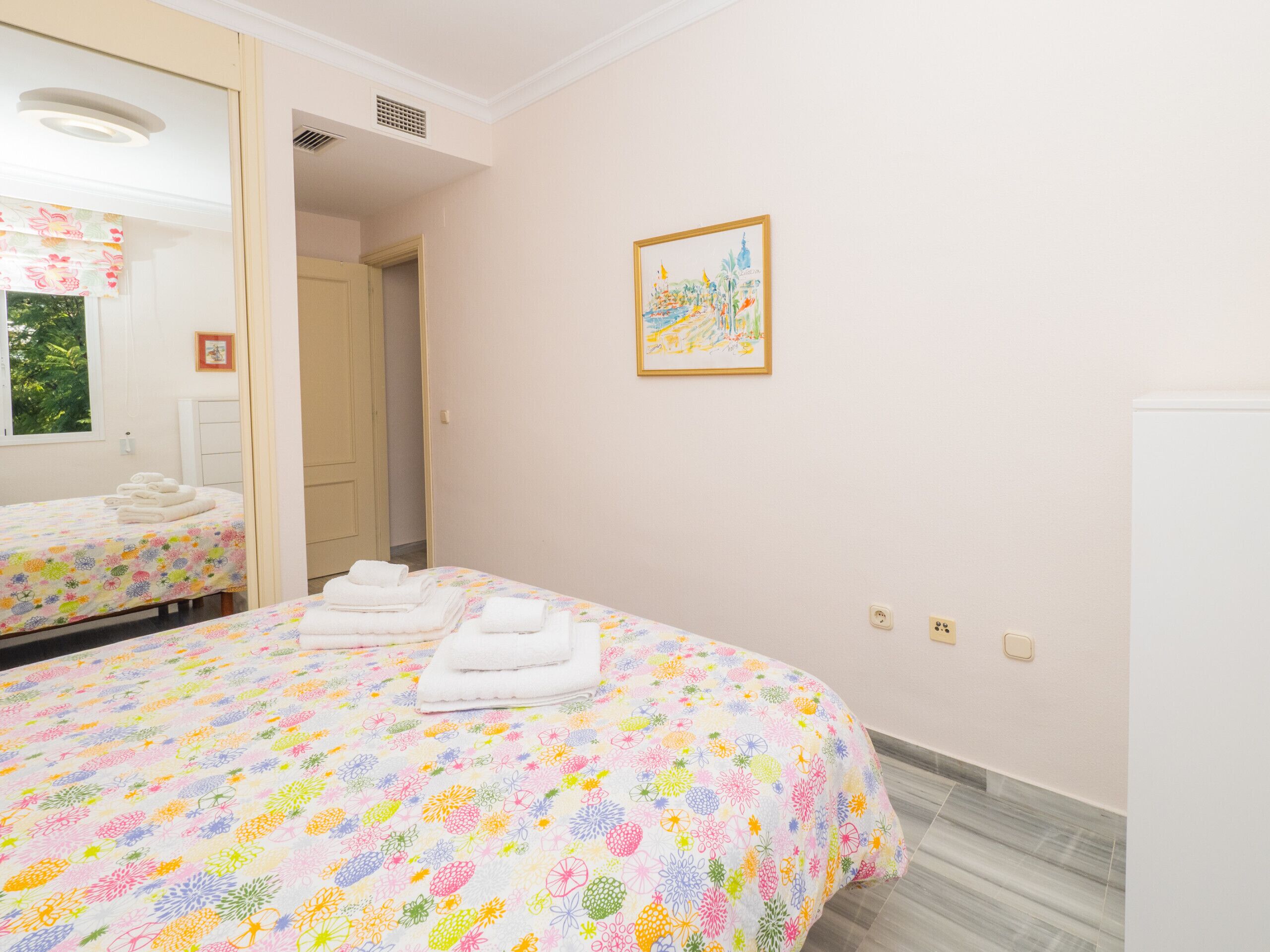 A hotel room with a bed, a bathroom, and a small window.