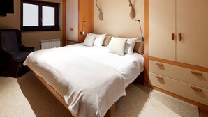 Ein Schlafzimmer mit einem großen Bett, einem Holzschrank und einem Sessel.