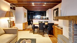 Ein gemütliches Wohnzimmer mit einer Couch, einem Couchtisch mit einer Kerze und einem Kamin.