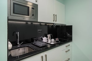 A modern kitchen with a microwave, sink, and stainless steel appliances.