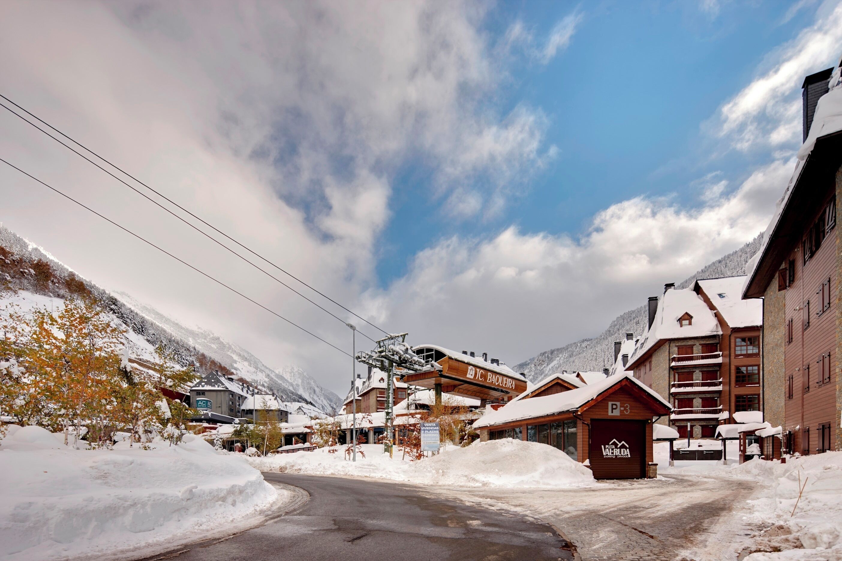 A snow-covered mountain resort with buildings, including a lodge marked "P3" and a sign for "TC Baierberg."