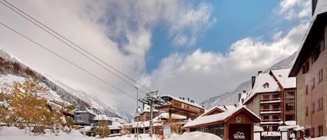A snow-covered mountain resort with buildings, including a lodge marked "P3" and a sign for "TC Baierberg."