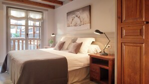 A bedroom with a bed, bedside table, lamp, and a painting of polar bears on the wall. - Val de Ruda Luxe 9 by FeelFree Rentals (Naut Aran)