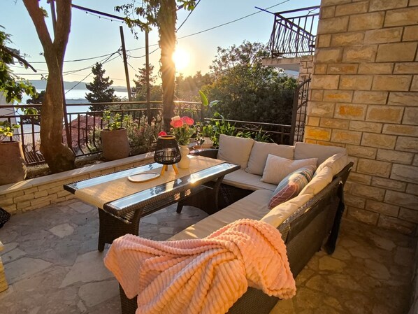 Un patio con un sofá, una mesa y una manta.