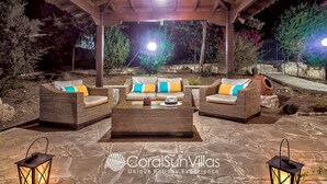 An outdoor seating area with wicker furniture and a stone floor. - Large Pool & Garden, Billiard, Peaceful Area, Near to the Sea, Coral Bay Paphos (Peyia)