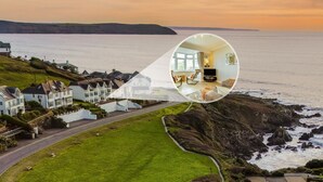 A coastal property with a view of the sea, a lawn, and a road leading to the sea. - 1 Bed in Woolacombe (oc-waves) (Woolacombe)