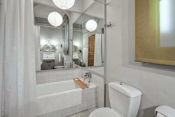 A bathroom with a white sink, mirror, and toilet.
