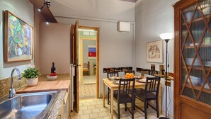 Une cuisine dotée de plans de travail en granit, d’un évier, d’une table à manger avec des chaises et d’une plante en pot.