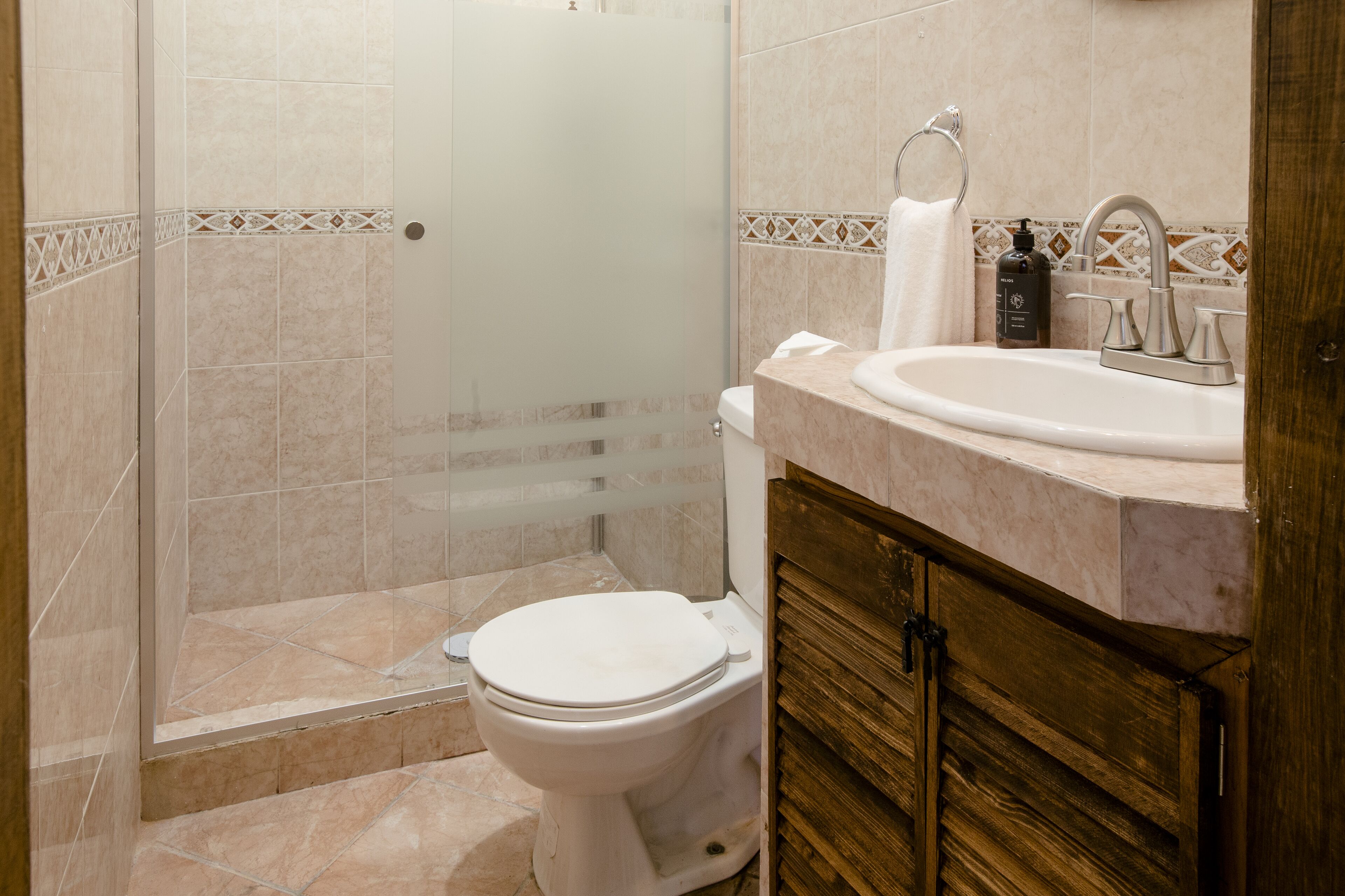 A bathroom with a toilet, a sink, and a shower area.