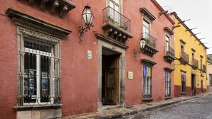 Una calle histórica con edificios que presentan balcones tradicionales y ventanas ornamentadas.