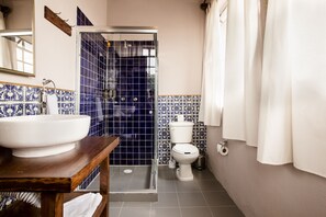 Ένα μπάνιο με λευκό νιπτήρα, τουαλέτα και χώρο για ντους.