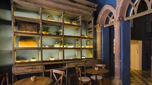 Una habitación con muebles de madera, un ventanal con estanterías y un suelo a cuadros.