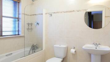 Un baño con bañera, inodoro y lavabo.