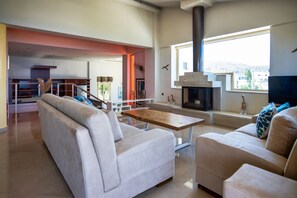 A modern living room with a sofa, a coffee table, and a fireplace.