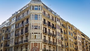 A multi-story building with a corner facade, balconies, and a clear sky. - Zabaleta Beach by FeelFree Rentals (Donostia)