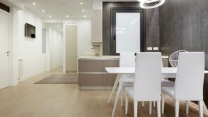 A modern kitchen with a central island, white cabinetry, and a built-in oven. - Zabaleta Beach by FeelFree Rentals (Donostia)