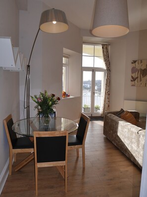 Relax in this inviting space with a glass-top dining table, comfortable seating, and a cozy sofa.