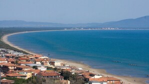A coastal town with a beach, houses with red roofs, and a clear blue sea. - Historic Stone House Casanova (Cinigiano)