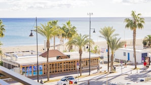 Ein Gebäude direkt am Strand, mit Restaurantschild, Palmen und Blick auf den Ozean.