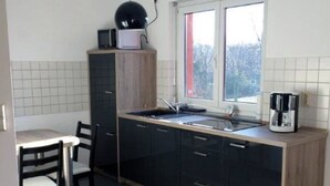 Cocina compacta con comedor, que incluye un lavamanos, microondas y cafetera.