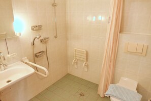 Kylpyhuone, jossa on pesuallas, suihku ja wc.
