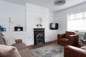 A living room with a fireplace, a television, and a sofa.