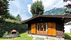 Una cabaña de madera con ventanas grandes y cimientos de piedra.