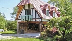 A Tudor-style house with a steeply pitched roof, dormer windows, and a wooden balcony.