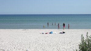 Une plage de sable blanc avec une eau bleue et calme.