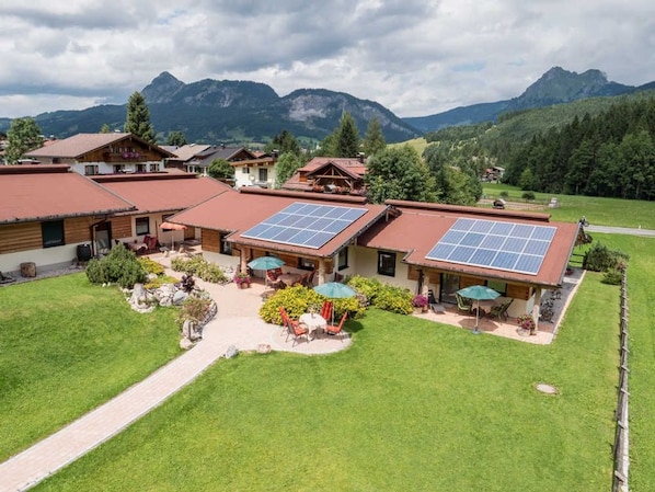 Un hotel con varias construcciones, paneles solares en los tejados y un césped bien cuidado.