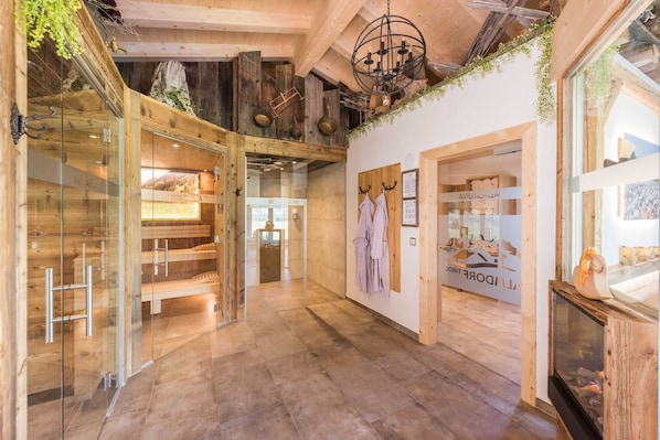A modern interior with wooden beams, a glass wall, and a fireplace.