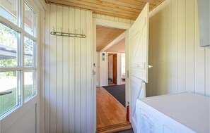 A narrow hallway with wooden flooring, a coat rack, and a door leading to another room. - 2 bedroom amazing home in Grenaa (Grenaa)