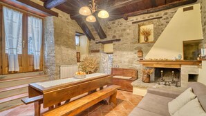 A rustic interior with a stone wall, wooden bench, fireplace, and a cozy seating area. - Beautiful home in Cortona (Ar) with outdoor swimming pool (Cortona (Ar))