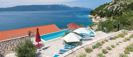 Area piscina con vista sul mare e sulle montagne.