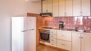 A compact kitchen with a refrigerator, oven, coffee maker, and a sink. - Amazing apartment in Makarska with WiFi (Makarska)