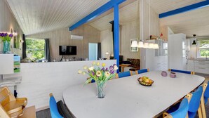 Una cuina àmplia i moderna, amb armaris blancs, una illa gran i detalls blaus.