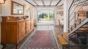 A spacious room with a wooden cabinet, a large mirror, and a patterned rug. A staircase leads to an outdoor area with a view of greenery. - Stunning home in Vrsar with WiFi (Vrsar)